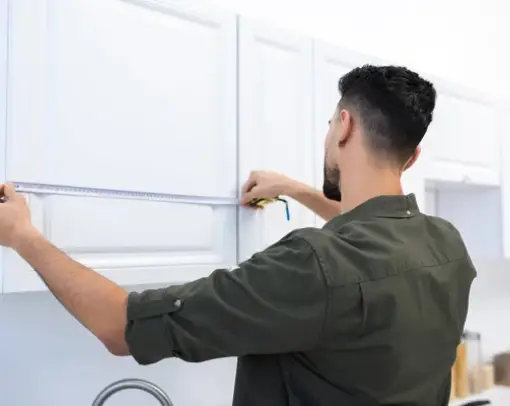 young man measuring kitchen | PriceCo Floors